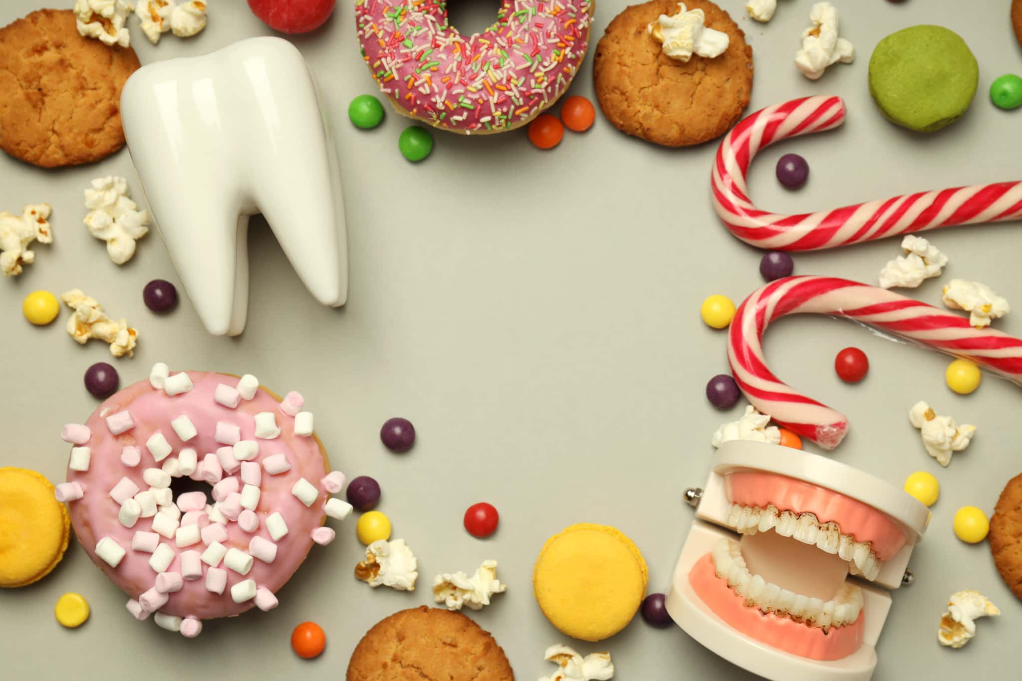 歯石ができやすい甘い食べ物と歯の模型のイメージ