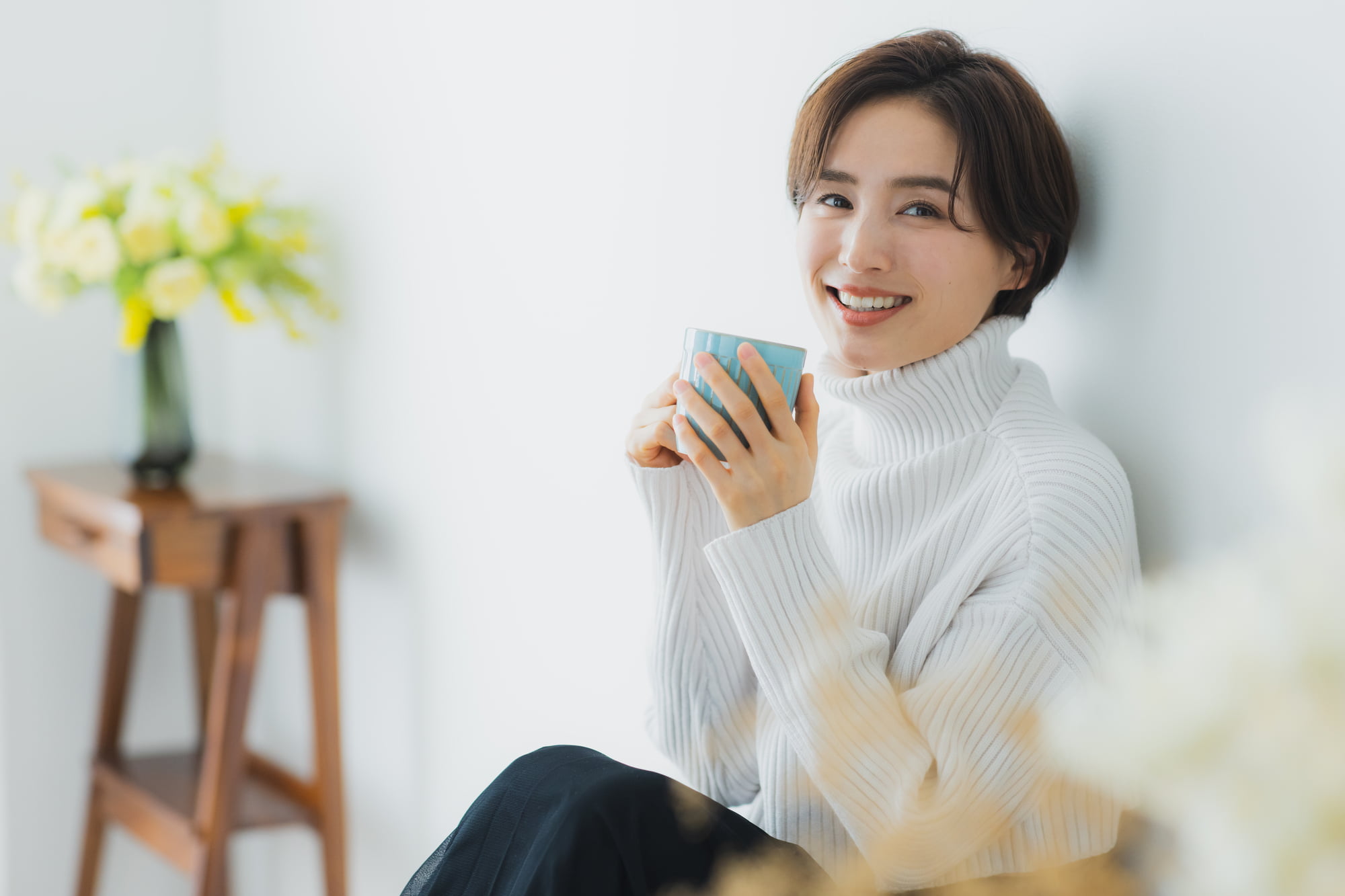 歯石のない美しい歯で飲み物を楽しんでいる女性