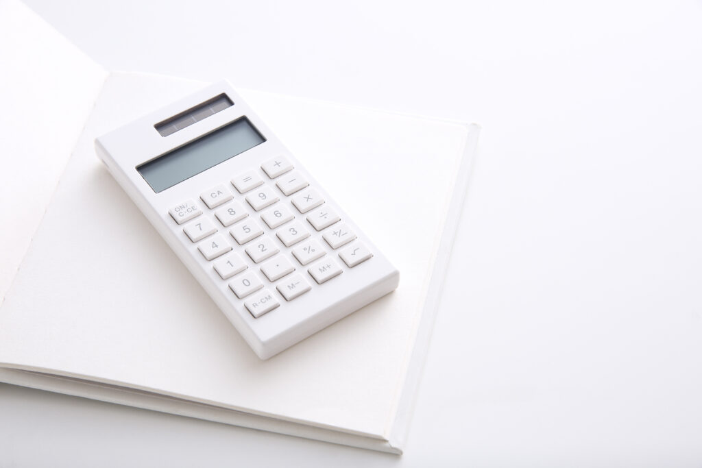 審美歯科治療の費用を計算するための電卓とノート