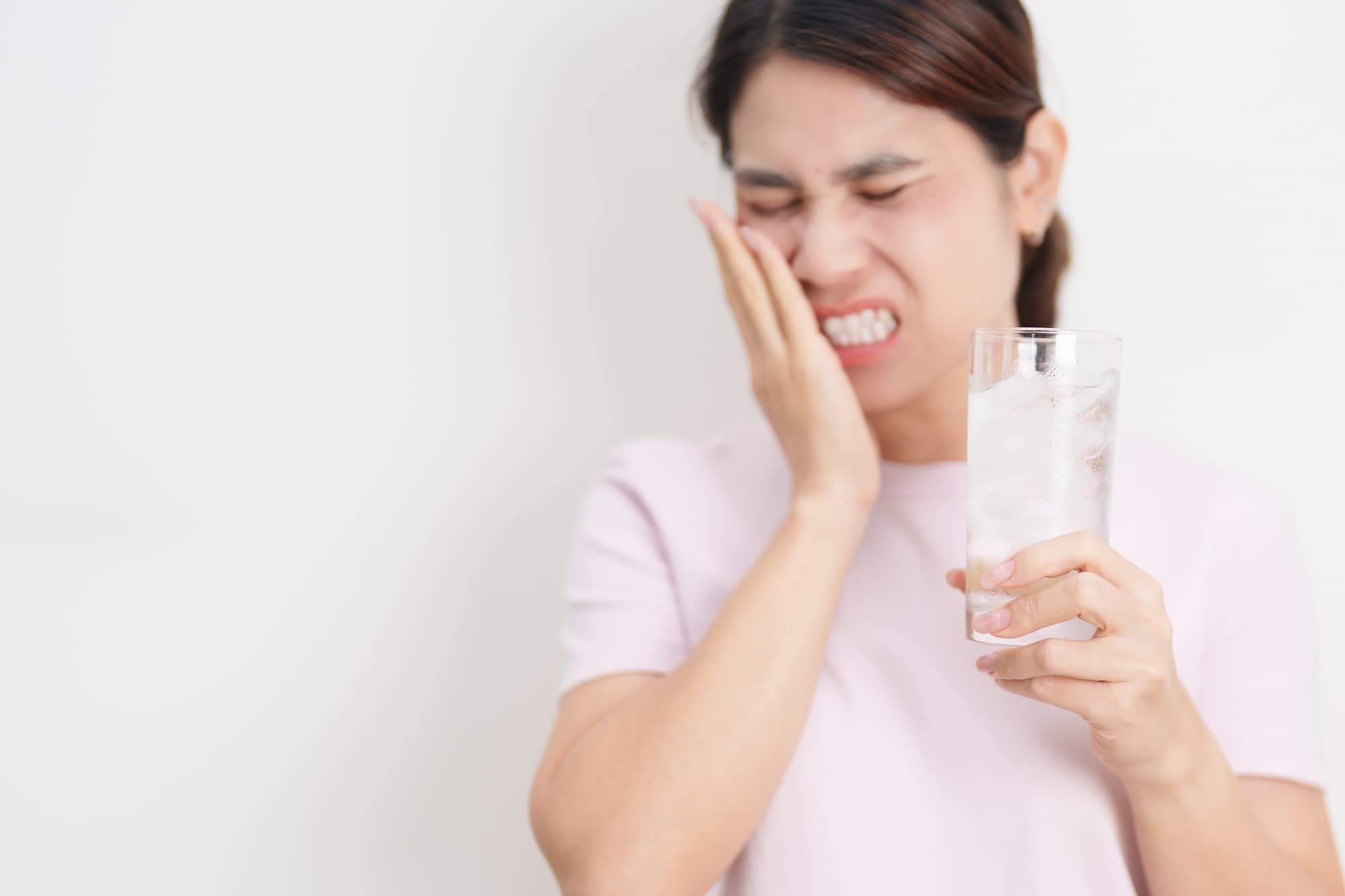 冷たい飲み物が歯にしみる女性