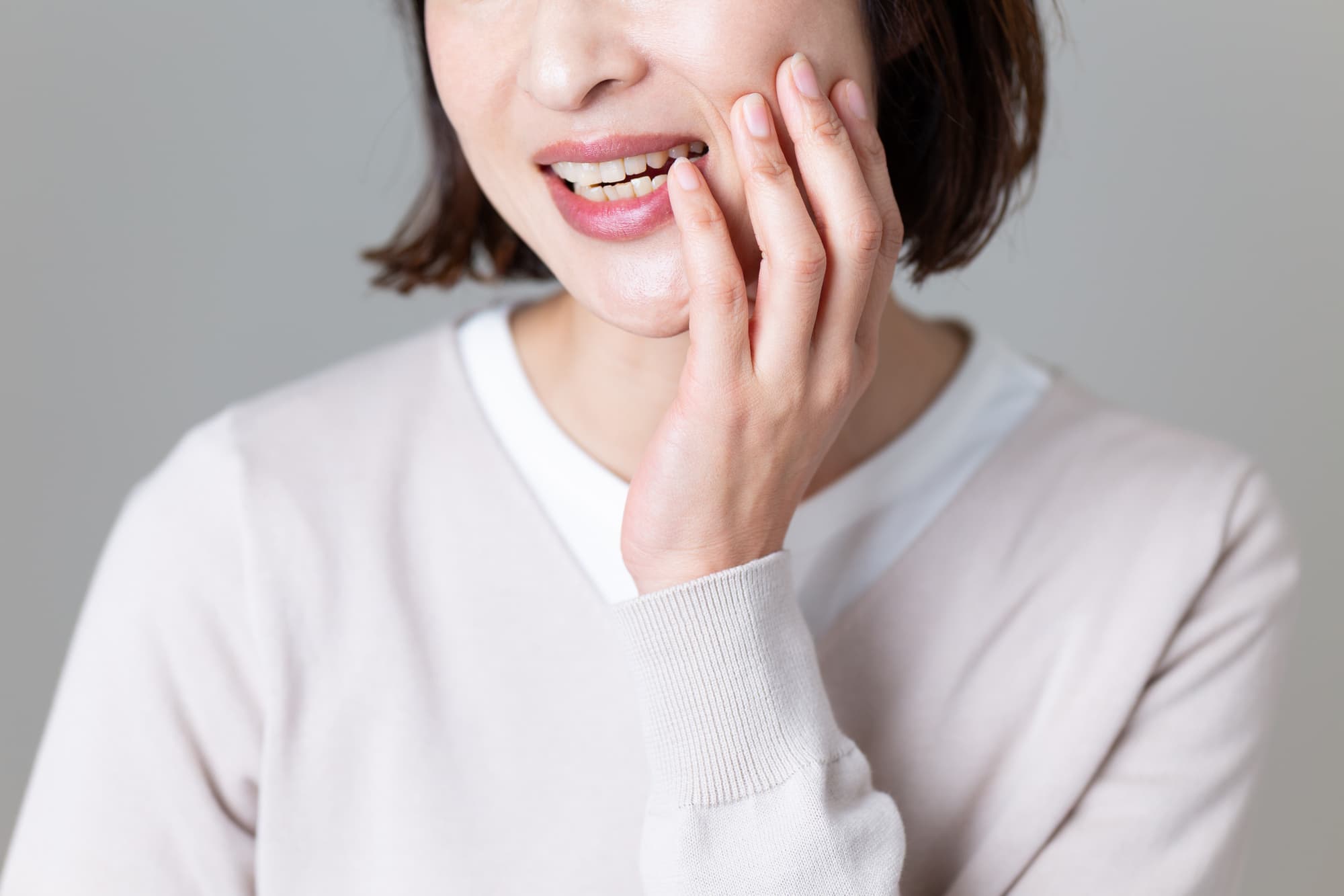 埋まっている親知らずが虫歯になって痛みを感じる女性