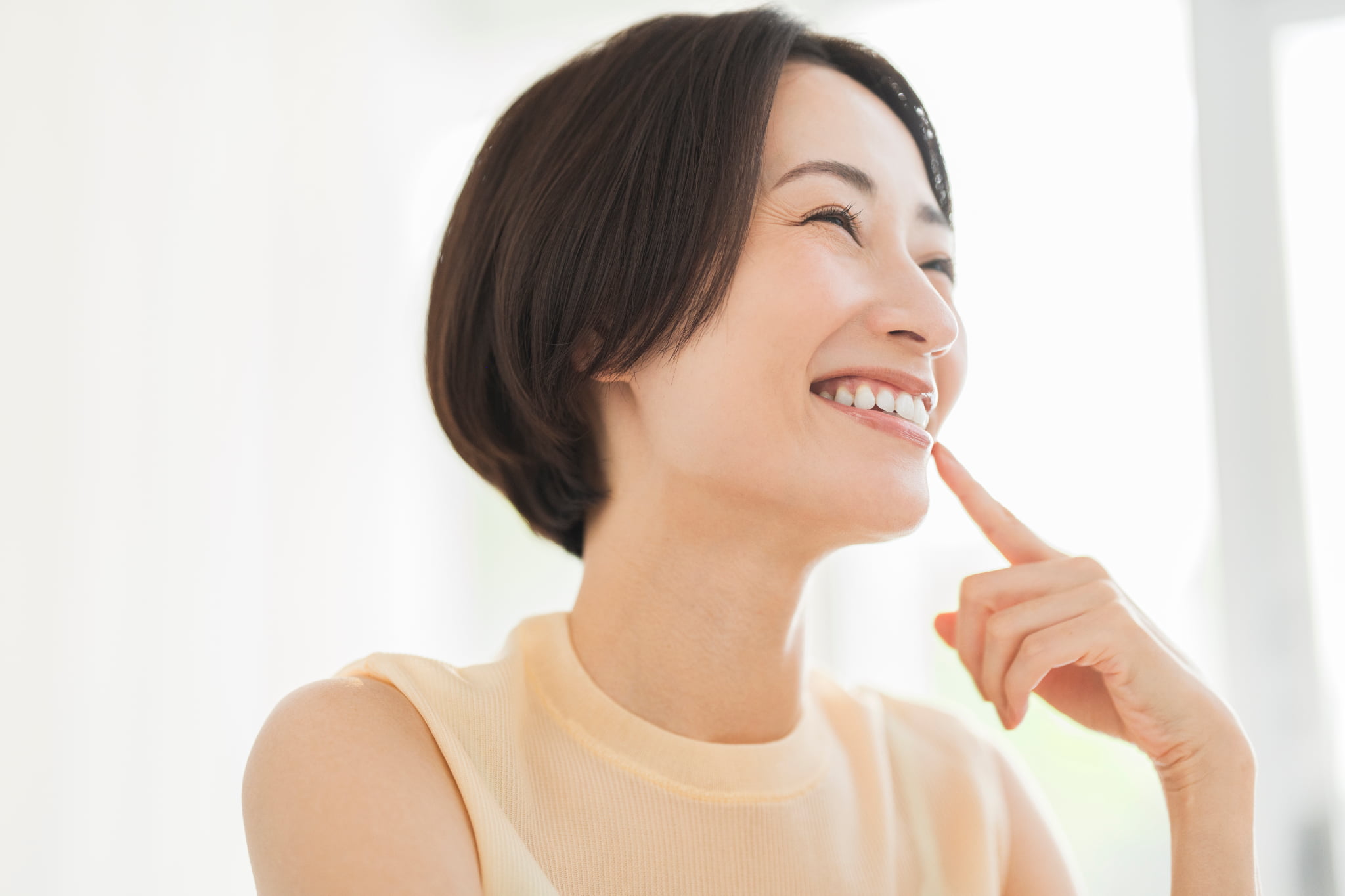 笑顔で歯を指さす女性