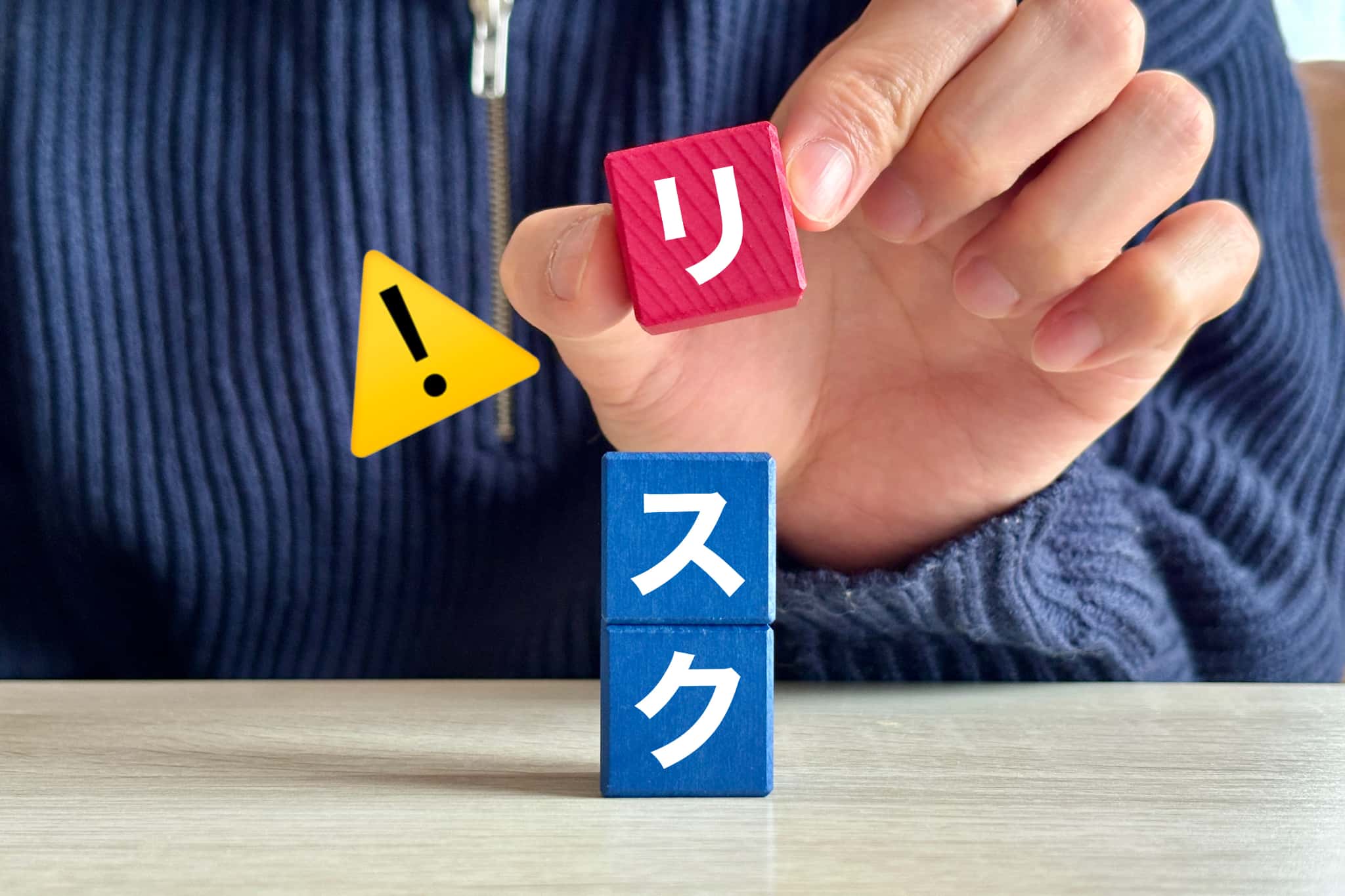 リスクと書かれたブロックを持つ手