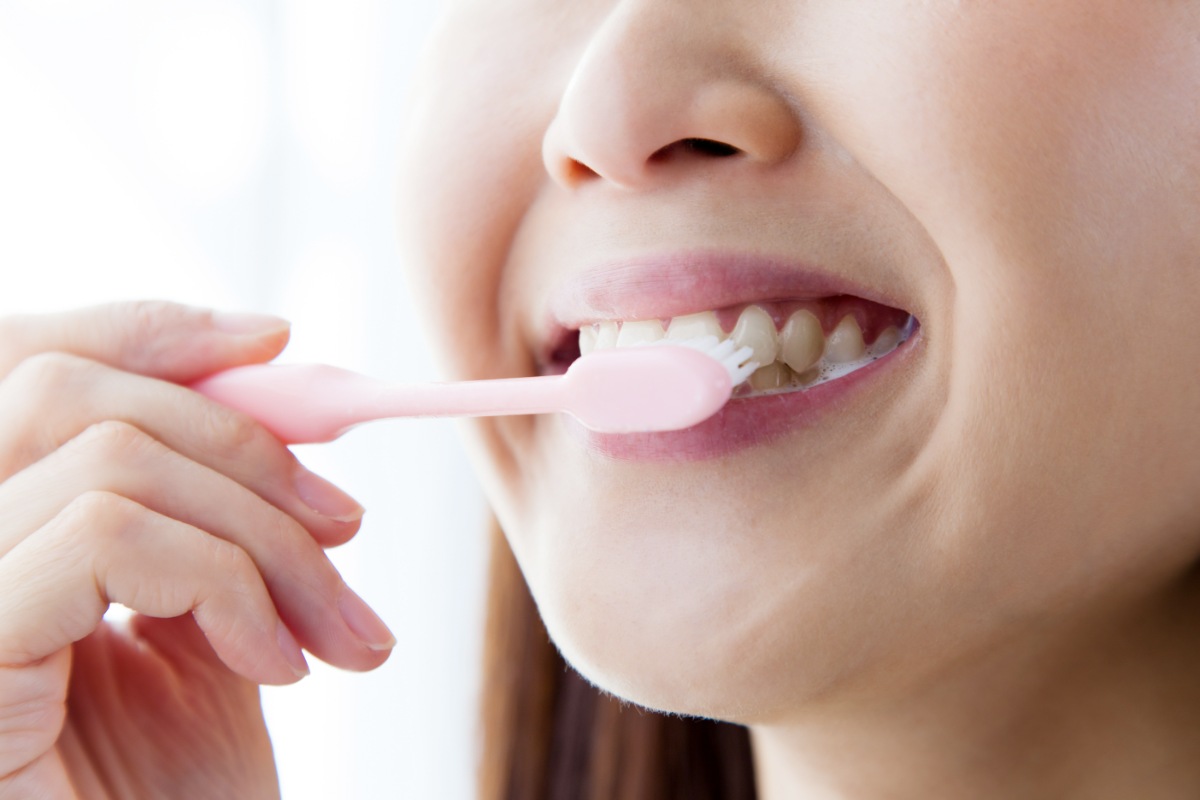 優しく歯を磨く女性の口元