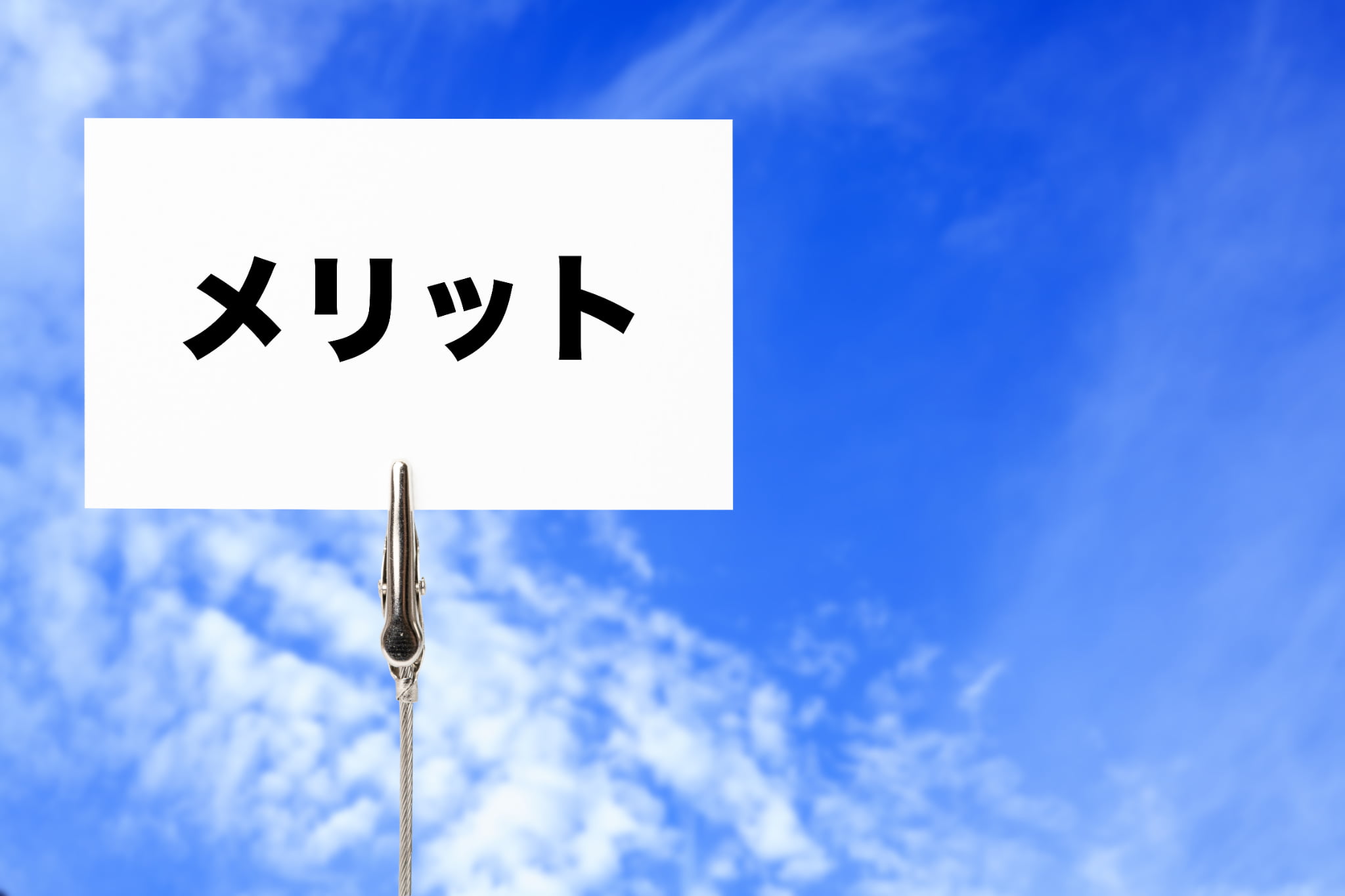 青空にメリットと書かれた白いカード